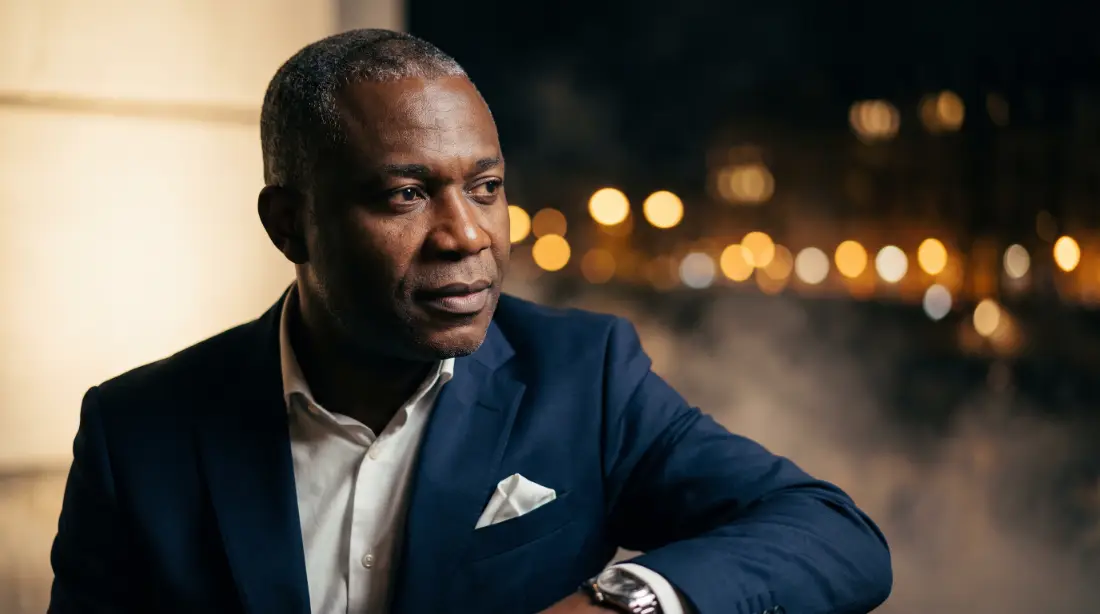 Client CarKonzi au regard posé, lumières de la ville au crépuscule
